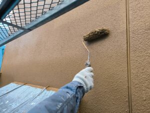 上塗り作業中の様子。ローラーで丁寧に塗膜を形成しています。