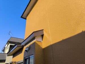 補修と塗装を終えた外壁。ひび割れが修復され、美しく塗り直された状態です。
